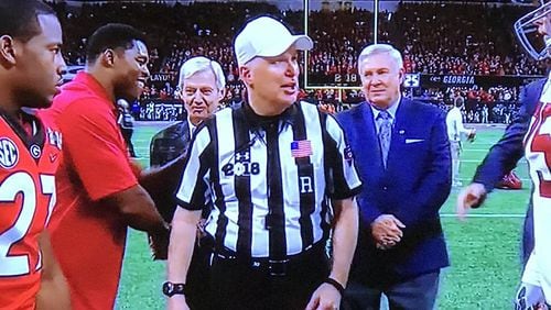 Big Ten referee Dan Capron, the lead official for the Georgia-Alabama National Championship Game, discusses ground rules with Nick Chubb and other players before the pregame coin toss on Jan. 8, 2018 at Mercedes-Benz Stadium.