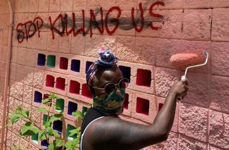 Yuzly Mathurin repairs tagging damage on her "Homegirl’s Clubhouse" mural, part of 2020's "Journey of a Black Girl" exhibition on the Atlanta BeltLine's Southside Trail. (Photo by Courtney Brooks)