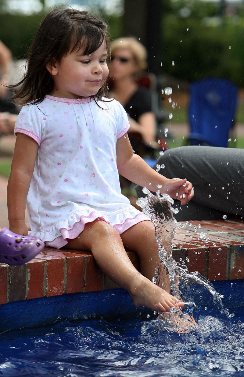 May 7, 2009: Two-year-old Emma Harding cools off by splashing her feet in the fountain during a free concert on Marietta Square.