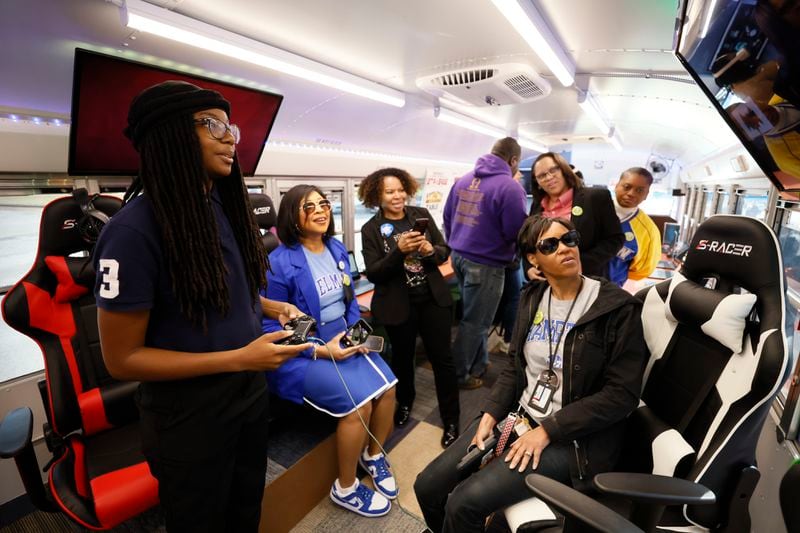 Lithonia High School student Ayana Lynch (left) checks out the gaming center inside the new Student Success Mobile Center on Wednesday, March 29, 2023. The retrofitted bus gives students a chance to explore career and college pathways with the latest technology. (Miguel Martinez / miguel.martinezjimenez@ajc.com)