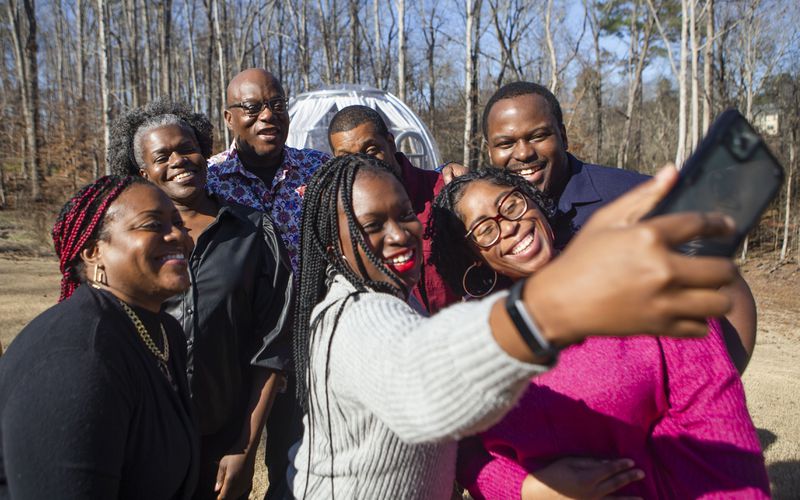 Amber Benoit takes a selfie with her family including Lewis Thompson (back middle) during a family reunion on Wednesday, December 27, 2022, in Suwanee, Georgia. At the event, Thompson, visiting from Australia, met four of his seven biological siblings for the first time. CHRISTINA MATACOTTA FOR THE ATLANTA JOURNAL-CONSTITUTION.