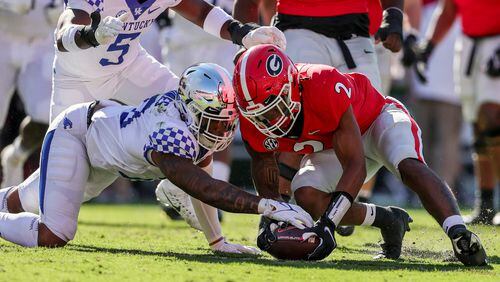 Georgia running back Kendall Milton (2) recovers a fumble as Kentucky linebacker Jacquez Jones battles for the ball during the first half Saturday, Oct. 16, 2021 in Athens. (Butch Dill/AP)