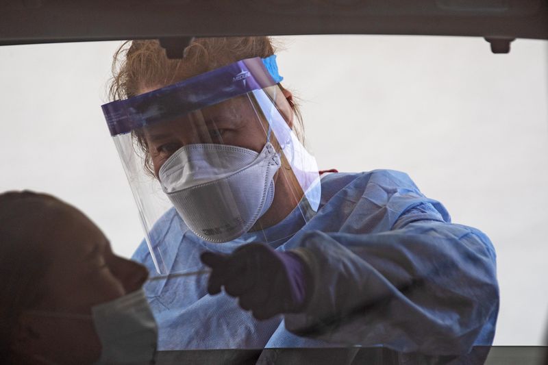 Nurse Kellie Kinard of the Jackson Nurse Professionals performs a COVID-19 test on a patient at a DeKalb County Board of Health drive-thru COVID-19 testing site in the parking lot of a closed K-Mart in Doraville, Thursday, August 27, 2020. The coronavirus pandemic is one of the key topics family disagree over, counselors say. (ALYSSA POINTER / ALYSSA.POINTER@AJC.COM)