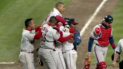 Braves catcher Javy Lopez (right) walks off the field as the Indians celebrate winning Game 3 of the World Series 7-6 in the 11th inning, Oct. 24, 1995, in Cleveland. (Marlene Karas/AJC)
