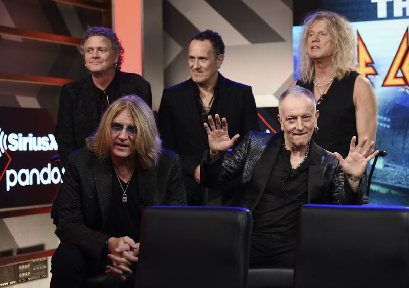 Rick Allen, from left, Joe Elliott, Vivian Campbell, Phil Collen and Rick Savage of Def Leppard sit for a a news conference to announce The Stadium Tour 2020 featuring Def Leppard, Poison and Motley Crue, at the SiriusXM offices, Wednesday, Dec. 4, 2019, in Los Angeles. (AP Photo/Chris Pizzello)