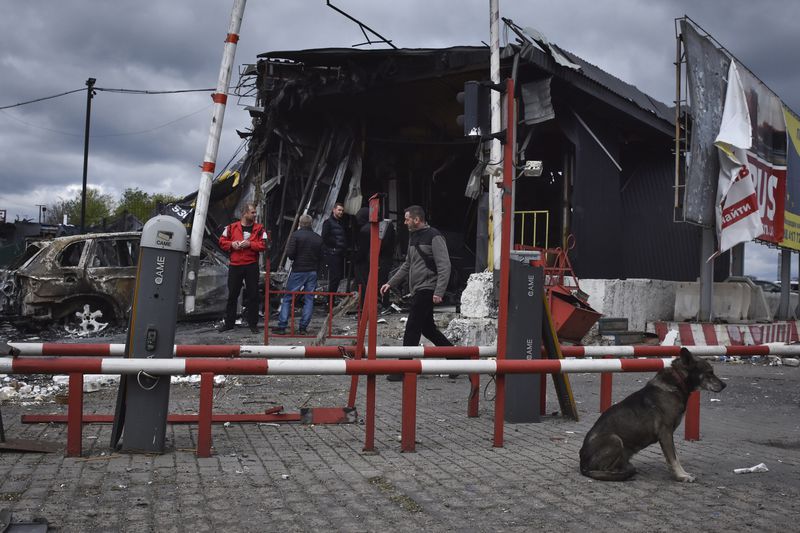 People stand at the scene of buildings damaged by Russian attack in Dnipro, Ukraine, Friday, April 19, 2024. (AP Photo/Andriy Andriyenko)