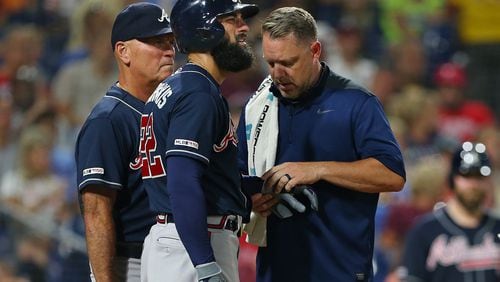 Nick Markakis #22 of the Atlanta Braves is looked at by a member of the team's medical staff along with manager Brian Snitker #43 after getting hit in the hand by a pitch during the sixth inning of a game against the Philadelphia Phillies at Citizens Bank Park on July 26, 2019 in Philadelphia, Pennsylvania. The Braves defeated the Phillies 9-2. (Photo by Rich Schultz/Getty Images)