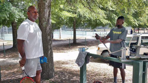 Darrell Hooker (left), prepares for a tennis lesson with Scott Ross at Trammell Crow Park. “I want to know how they are going to enforce it” Ross said of the smoking ban. Fulton County has approved a smoking ban in county parks. Smokers will get $1,000 fine or jail time. BOB ANDRES /BANDRES@AJC.COM