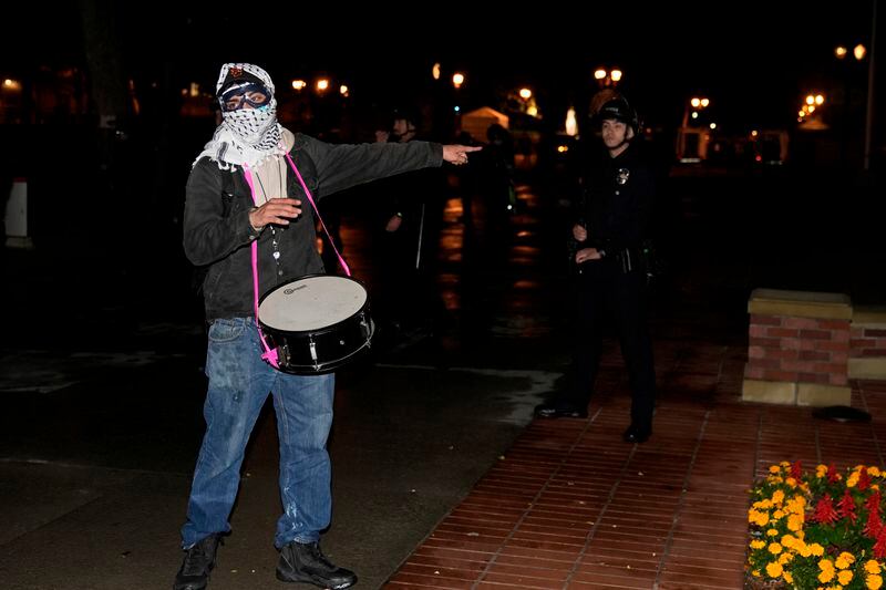 A protestors gestures near police officers after a raid on the pro-Palestinian encampment on the campus at the University of Southern California Sunday, May 5, 2024, in Los Angeles. (AP Photo/Ryan Sun)
