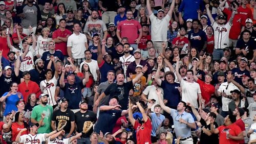 Fans try to catch a home run by the Braves' Ozzie Albies in the fifth inning at Truist Park on Friday, May 21, 2021. (Hyosub Shin / Hyosub.Shin@ajc.com)