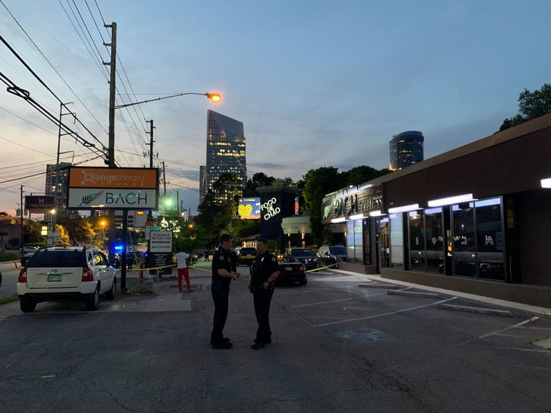 Police stand and talk Wednesday night outside Fogo de Chao, where an officer was involved in a shooting earlier in the evening.