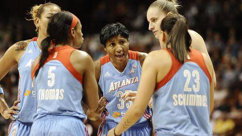 Angel McCoughtry, center, huddles with her Dream teammates during the second half of a WNBA basketball game against the Connecticut Sun, Sunday, Aug. 17, 2014, in Uncasville, Conn. (AP Photo/Jessica Hill)