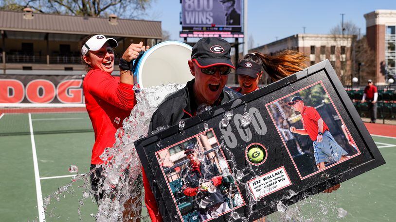 Georgia coach Jeff Wallace gets a surprise water-cooler bath after the Bulldogs won the 800th match of his career as the women's tennis coach against Missouri at Henry Feild Stadium at the Dan Magill Tennis Complex in Athens, on Sunday, March 5, 2023. Wallace, who has since won 14 more matches, announced his retirement Friday after 38 years on the job. (Kayla Renie/UGA Athletics)