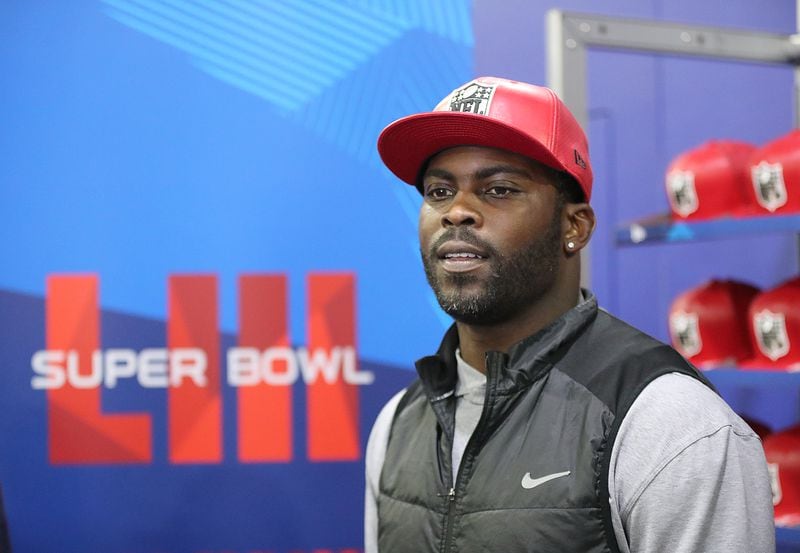 Jan. 31, 2019 Atlanta: Former Falcons and Eagles quarterback Michael Vick wears one of his special edition New Era #7 hats on sale in the NFL Shop at the Super Bowl Experience on Thursday, Jan. 31, 2019, in Atlanta.  Curtis Compton/ccompton@ajc.com