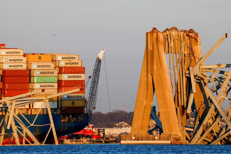 Cranes stand by as the wreckage of the Francis Scott Key Bridge rests on the container ship Dali, Saturday, March 30, 2024, in Baltimore. (AP Photo/Julia Nikhinson)