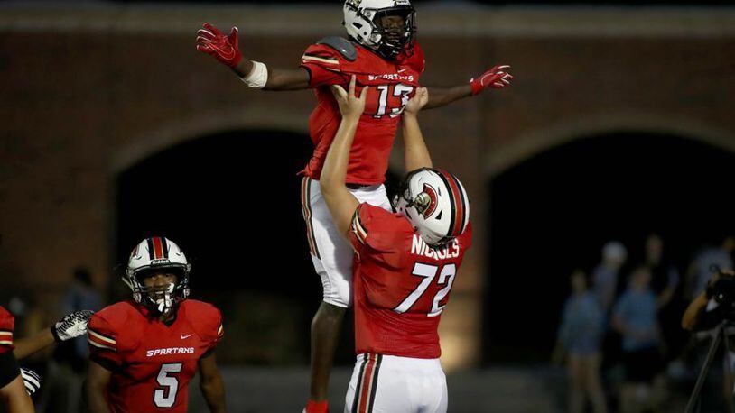 GAC wide receiver Ty James (13) celebrates a touchdown reception with offensive lineman Addison Nichols (72) in the first half of their game against Westminster at Greater Atlanta Christian Friday, August 24, 2018, in Norcross, Ga. PHOTO / JASON GETZ