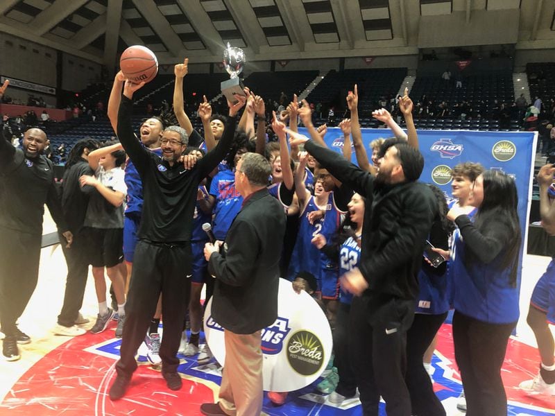 Coach Buck Jenkins holds up the Class 6A championship trophy after his Riverwood team beat Alexander 67-63 in overtime on March 8 2024 at the Macon Coliseum.