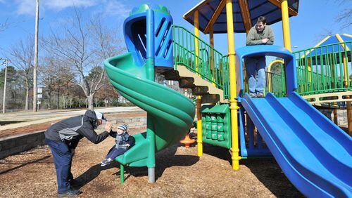Seth Freedman (right) watches his son Benjamin, 2, and his father, Chuck Freedman, at a playground at Waller Park Extension, recently renamed Groveway Community Park by the Roswell City Council. HYOSUB SHIN/HSHIN@AJC.COM