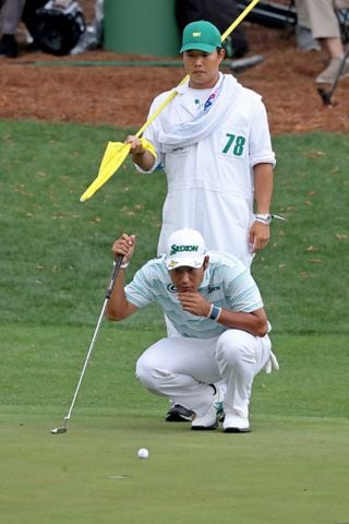 April 10, 2021, Augusta: Hideki Matsuyama and his caddie Shota Hayafuji look over his birdie putt on the sixteenth hole during the third round of the Masters at Augusta National Golf Club on Saturday, April 10, 2021, in Augusta. Curtis Compton/ccompton@ajc.com