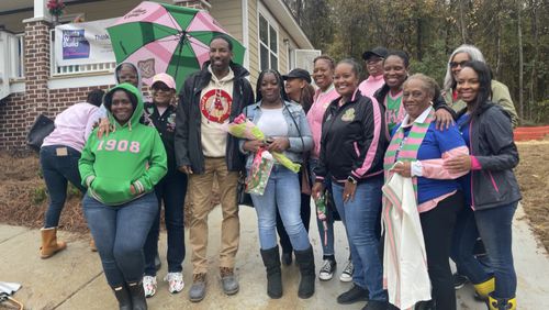 Atlanta Mayor Andre Dickens, Pi Alpha Omega president Brianca Martin, and chapter members stand with homeowner Tekia Rice (center, holding flowers) at her home dedication last month. She'll move in just before Christmas and have a 7-foot tree, compliments of one of the sorority sisters to enhance the celebration. Photo courtesy of Pi Alpha Omega.