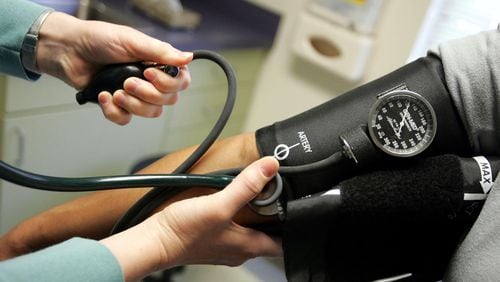 File photo of a doctor checking a patient's blood pressure.