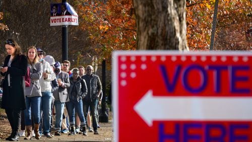 Voters at the Joan P. Garner library line up out the door and down the road as early voting is in full swing in Fulton county on Monday, Nov. 28, 2022.  (Ben Hendren for the Atlanta Journal Constitution) 