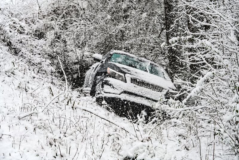 A car is abandoned on the side of the road in Cumming after Saturday morning's snow.