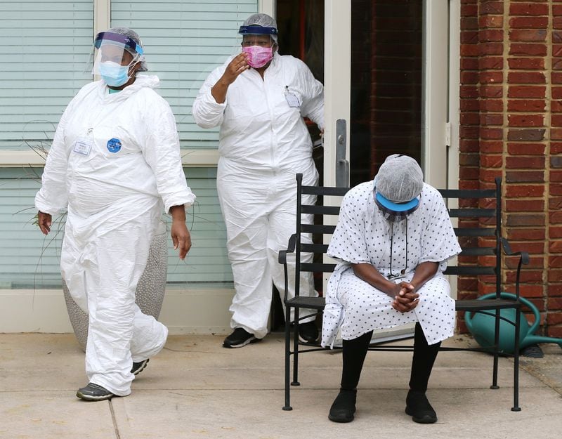 Housekeeper Belinda Moore (right) bows her head while members of Rock Springs Church hold an outdoor prayer service for the longterm care workers battling through the pandemic at Westbury Medical Care & Rehabilitation on May 8, 2020, in Jackson. CURTIS COMPTON / CCOMPTON@AJC.COM