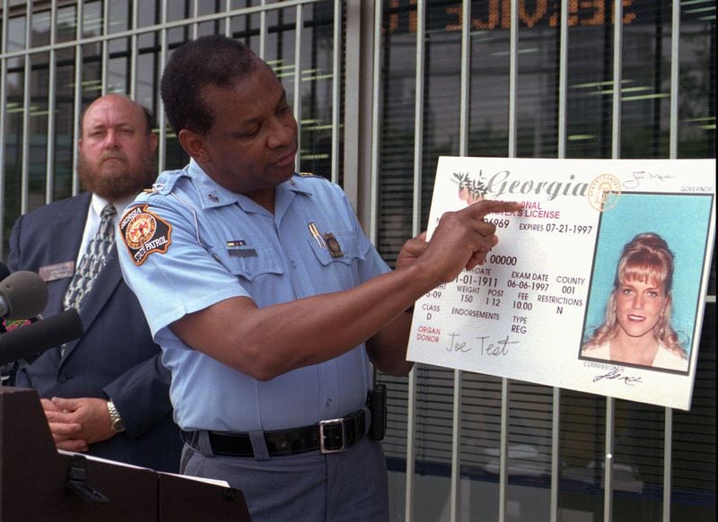 Maj. Robert Hightower of the Department of Public Safety points to a new feature on a teenagers' driver's license during a June 1997 news conference in Atlanta. Rep. Warren Massey, R-Winder, is in the background. (AP Photo/Alan Mothner)