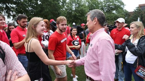 Governor Brian Kemp greets UGA juniors Susannah Hicks, left, and Drew Fiscus as Kemp visits the UGA College Republicans at Herty Field before the Georgia football team hosted Samford, Saturday, September 10, 2022, in Athens. (Jason Getz / Jason.Getz@ajc.com)