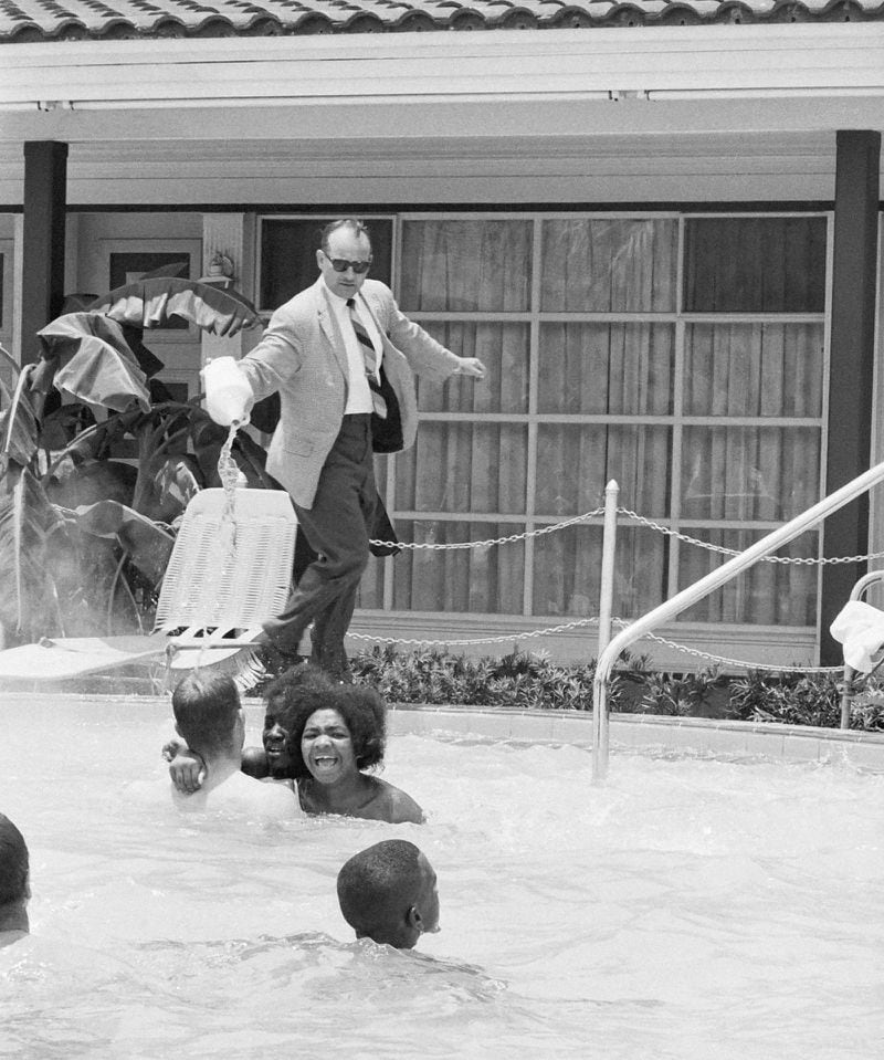 When a group of white and African American integrationists entered a segregated hotel pool, June 18, 1964, in St. Augustine, FL., manager James Brock poured muriatic acid into it, shouting "I'm cleaning the pool." The demonstrators refused to leave and were arrested. (AP Photo/Horace Cort)