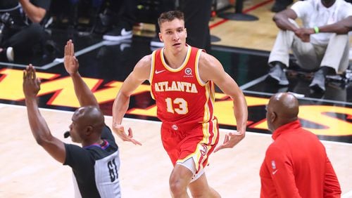 The Atlanta Hawks' Bogan Bogdanovic reacts to hitting a 3-pointer against the Philadelphia 76ers with interim head coach Nate McMillan looking on in Game 3 of their Eastern Conference semifinal at State Farm Arena on Friday, June 11, 2021, in Atlanta. The Sixers won, 127-111, for a 2-1 series lead. (Curtis Compton/Atlanta Journal-Constitution)