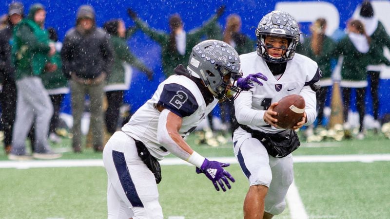 Justin Robinson (background) hands the ball to Eagle's Landing Christian Academy teammate Keaton Mitchell during the Class A-Private championship game Dec. 13, 2019, at Georgia State Stadium in Atlanta.