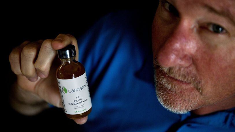Georgia state Rep. Allen Peake, R-Macon, displays a bottle of cannabis oil in his office in Macon. Peake, the author of the bill that began the state’s medical marijuana program, still hopes one day the state will allow the production of the oil within Georgia’s borders. (AP Photo/David Goldman)