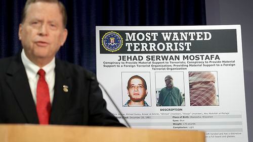 U.S. Attorney Robert Brewer speaks in front of an FBI poster depicting Jehad Serwan Mostafa during a news conference in San Diego.