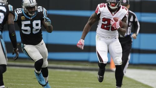 Falcons’ Tevin Coleman runs past the Panthers’ Thomas Davis on his 31-yard reception on third-and-21 in Charlotte, N.C., on Saturday, Dec. 24, 2016. (AP Photo/Bob Leverone)
