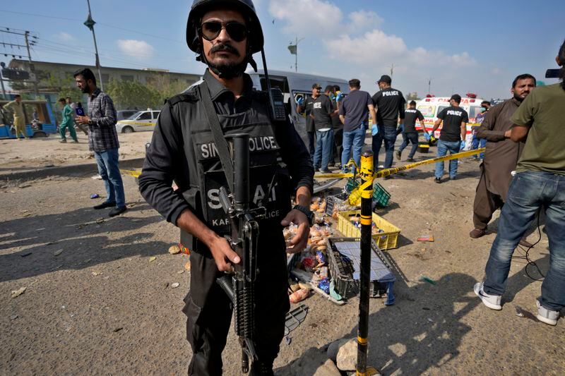 A police officer stands guard at the site of suicide attack in Karachi, Pakistan, Friday, April 20, 2024. Five Japanese nationals traveling in a van narrowly escaped a suicide attack when a suicide bomber detonated his explosive-laden vest near their vehicle in Pakistan's port city of Karachi on Friday, wounding three passers-by, police said. (AP Photo/Fareed Khan)