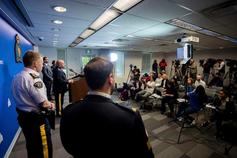 Media ask questions to Assistant Commissioner David Teboul, centre, Commander of the Federal Policing Program in the Pacific Region, during a news conference for an update on the Hardeep Singh Nijjar homicide investigation from June 18, 2023, in Surrey, B.C., Friday, May 3, 2024. (Ethan Cairns/The Canadian Press via AP)