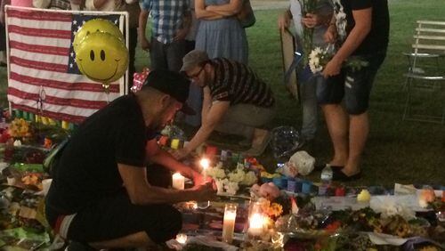 Residents light candles and leave flowers at a downtown Orlando shrine to victims. Photo: Jennifer Brett, jbrett@ajc.com