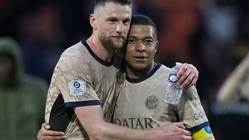 PSG's Milan Skriniar, left, hugs Kylian Mbappe after winning the French League One soccer match between Lorient and Paris Saint-Germain at the Moustoir stadium in Lorient, Brittany, western France, Wednesday, April 24, 2024. (AP Photo/Michel Euler)