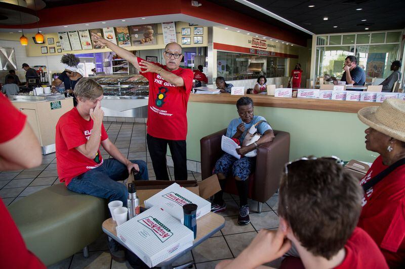 Former state Sen. Vincent Fort, center, talks with volunteers at the Kruspy Kreme in the West End neighborhood of Atlanta October 6, 2018. Critics of the Gulch deal called the Red Light the Gulch Coalition canvassed the southwest area of Atlanta. STEVE SCHAEFER / SPECIAL TO THE AJC