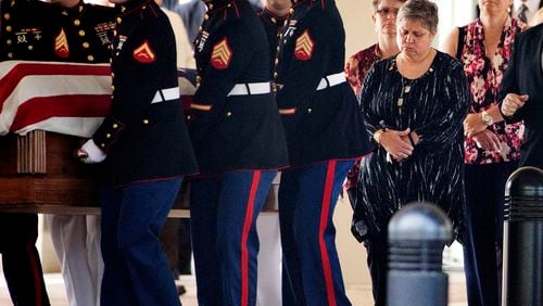 Cathy Wells, the mother of Lance Cpl. Squire Wells, known as "Skip," right, follows the casket of her son as U.S. Marines carry it to a hearse following his funeral service, Sunday, July 26, 2015, in Woodstock, Ga. The 21-year-old Wells was killed July 16 when a man opened fire at two military facilities before being killed by police in Chattanooga, Tenn. (AP Photo/David Goldman)