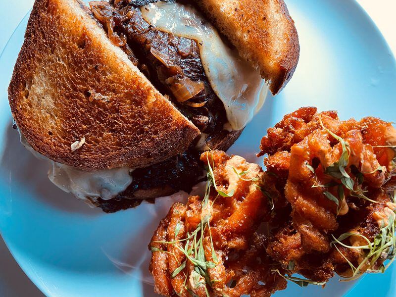The Porter Beer Bar’s double smashed patty melt is made with two beef patties, caramelized onions, Swiss cheese and rye bread. It comes with a side of sweet potato waffle fries. Bob Townsend for The Atlanta Journal-Constitution.