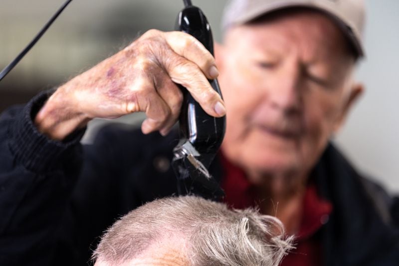 James “Soapy” Herndon cuts the hair of his customer Michael Harper in Americus on Saturday, March 4, 2023. Soapy was a longtime barber to Jimmy Carter. (Arvin Temkar / arvin.temkar@ajc.com)