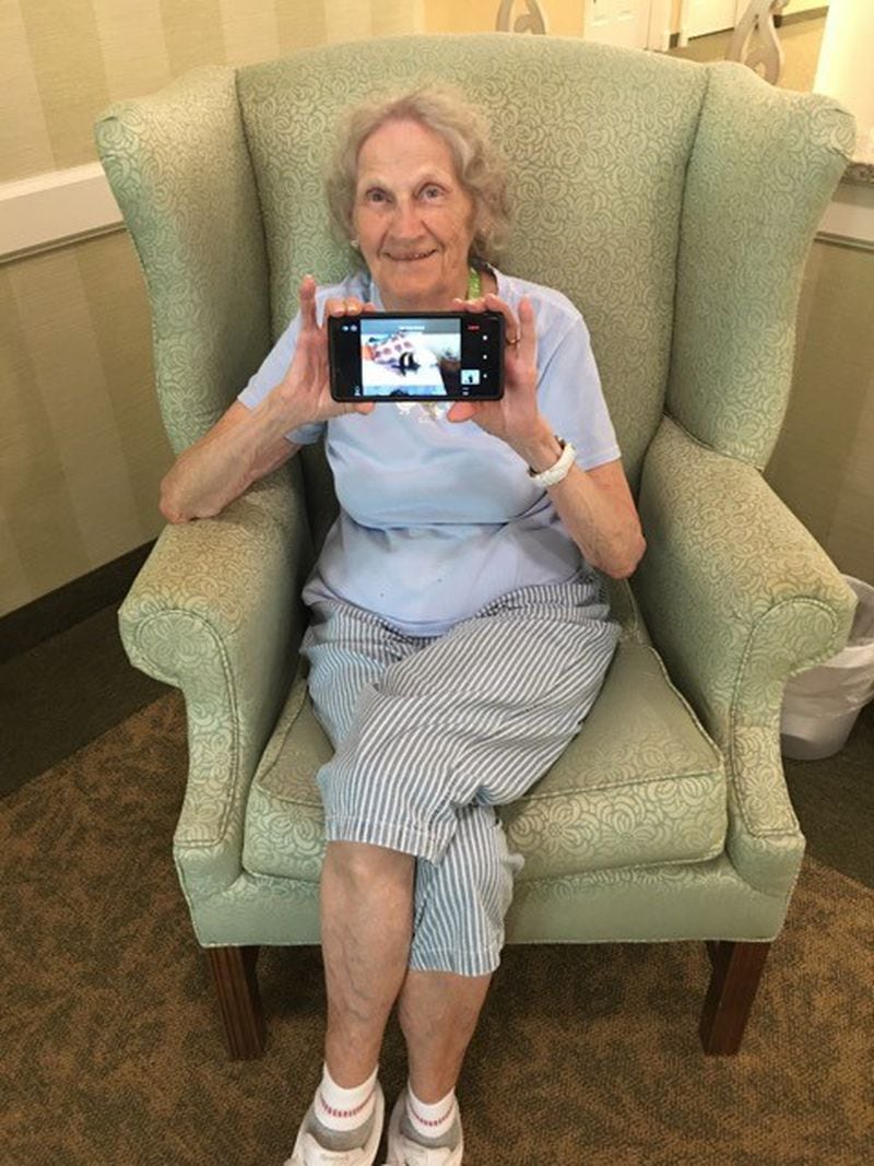 Brennity uses her phone to interact with pets and volunteers in her senior living community at Vero Beach, Florida. Pets Together is a free virtual pet visit being offered across the country to those living in group settings, such as nursing homes and senior living communities. Courtesy of Pets Together

 