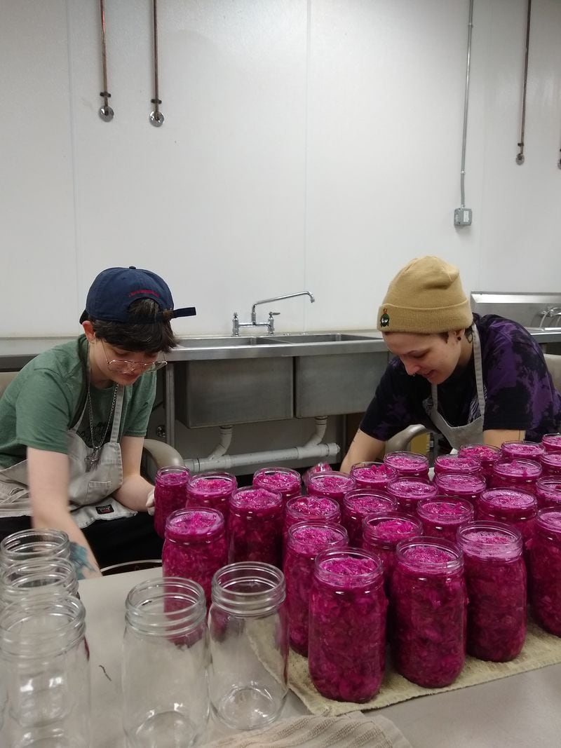 Cultured Traditions staffers T. Bolick (left) and Kaitlin Valentine package the company’s Russian-style red sauerkraut. Courtesy of Cultured Traditions 