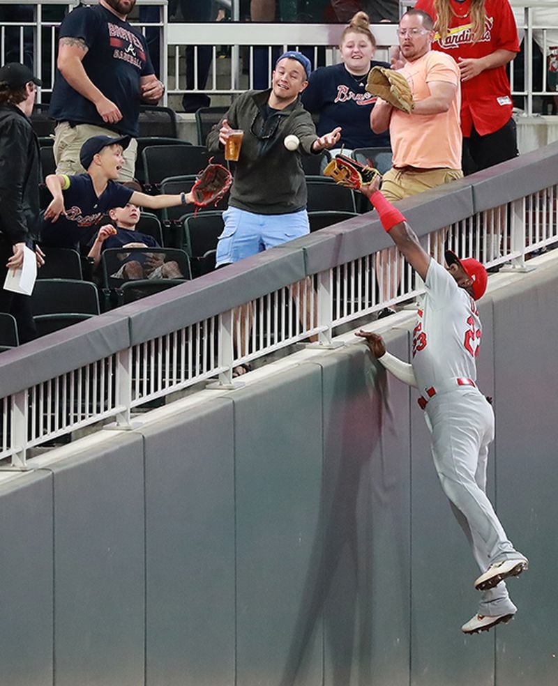 St. Louis Cardinals outfielder Marcell Ozuna goes to the wall but can't quite reach a foul ball by Braves Johan Camargo during the seventh inning Tuesday, May 14, 2019, in Atlanta.