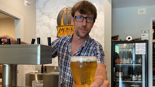 Justin Schoendorf serves a glass of Belgian Brut mead at the new Monks Meadery taproom in Atlanta. (Bob Townsend for The Atlanta Journal-Constitution)