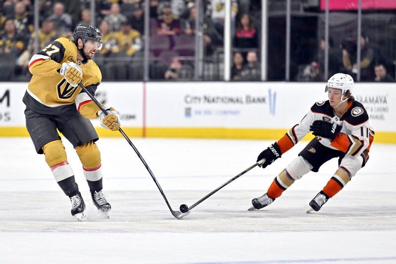 Vegas Golden Knights defenseman Shea Theodore (27) and Anaheim Ducks center Trevor Zegras (11) vie for the puck during the second period of an NHL hockey game Thursday, April 18, 2024, in Las Vegas. (AP Photo/David Becker)