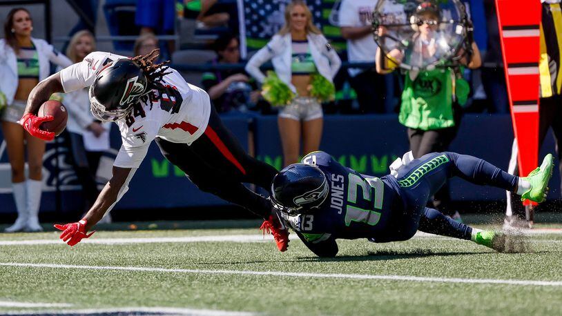 Falcons running back Cordarrelle Patterson dives past Seahawks safety Josh Jones for a 17-yard touchdown during the second quarter Sunday at Lumen Field in Seattle. (Jennifer Buchanan/The Seattle Times/TNS)